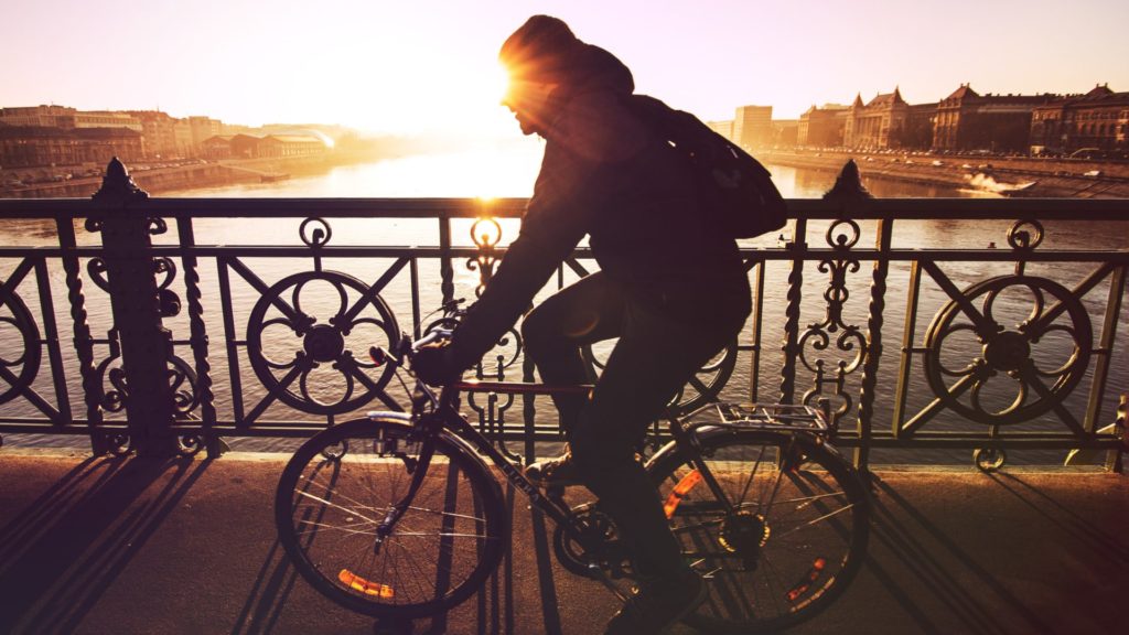Mann fährt im Sonnenuntergang mit dem Fahrrad