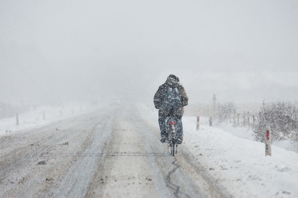 Fahrradfahrer bei dichtem Schneefall