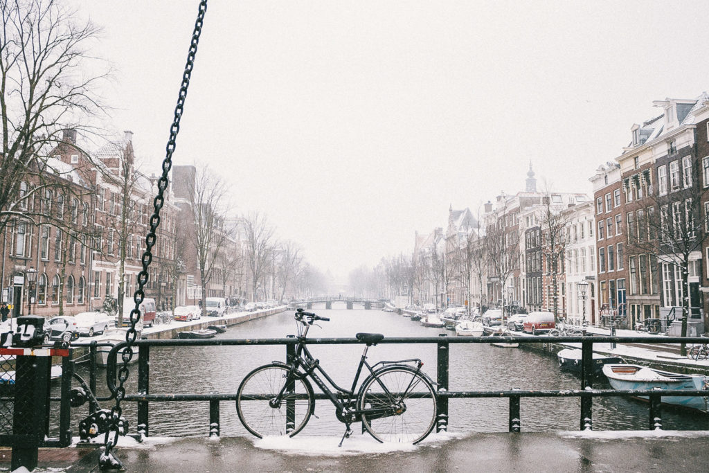 Fahrrad im Schnee an einer Brücke stehend