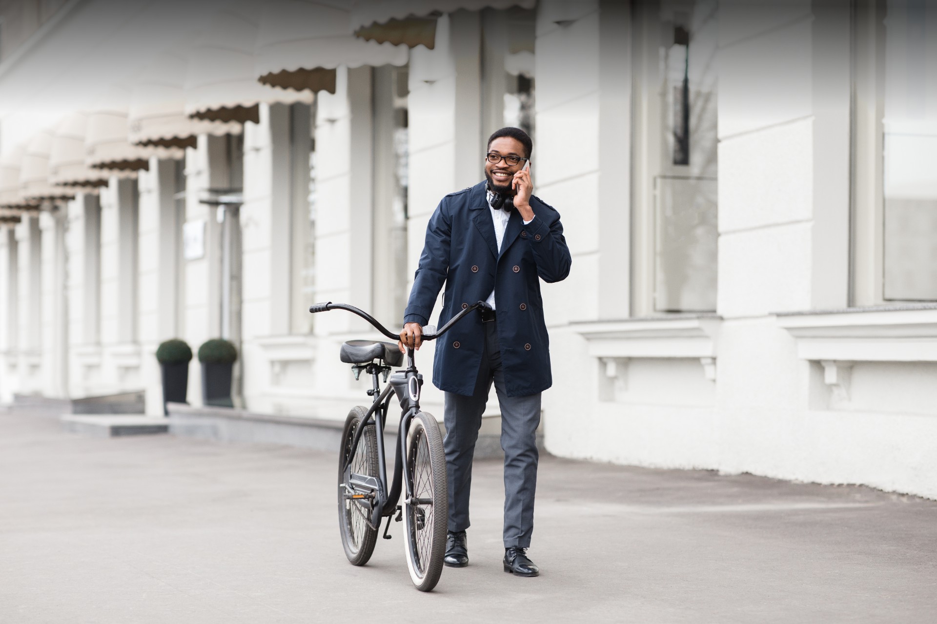 Businessmann telefoniert und schiebt ein Fahrrad
